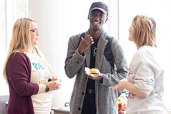 Three students smiling and talking
