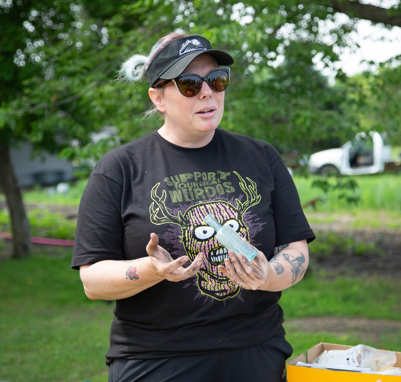 Amanda Butler holding a glass bottle recovered from a trash pit