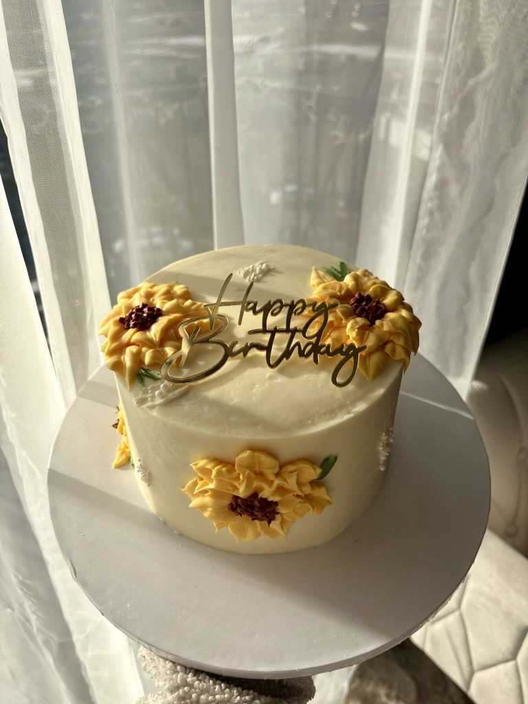 A yellow and white cake that says Happy Birthday.